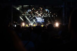 Photographie de concert en plein air à Asnières, scène illuminée "Paris Select Live Band" et silhouettes de la foule, reportage événementiel nocturne.