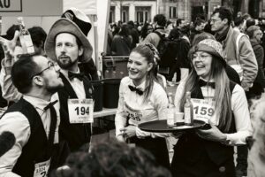 Photographie de groupe en noir et blanc de serveurs et serveuses souriants avant la Course des Cafés à Paris, portraits lifestyle événementiels.