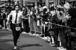 Photographie en noir et blanc de la Course des Cafés à Paris, serveur en action avec son plateau devant une foule de spectateurs, reportage photo urbain.
