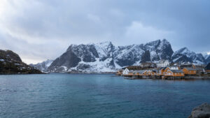 Village de pêcheurs d'Hamnøy avec ses rorbuer jaunes au pied de montagnes enneigées des îles Lofoten, Norvège.