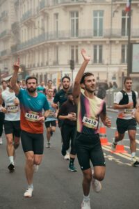 Photographie de reportage sportif, coureurs masculins saluant la foule lors du Semi-marathon de Paris, style lifestyle urbain et dynamique.