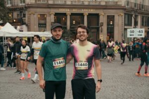 Portrait de deux coureurs devant l'Hôtel du Louvre lors du Semi-marathon de Paris, photographie de reportage événementiel urbain.