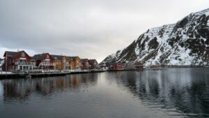 Maisons de pêcheurs traditionnelles rorbuer rouges et jaunes au bord d'un fjord en Norvège